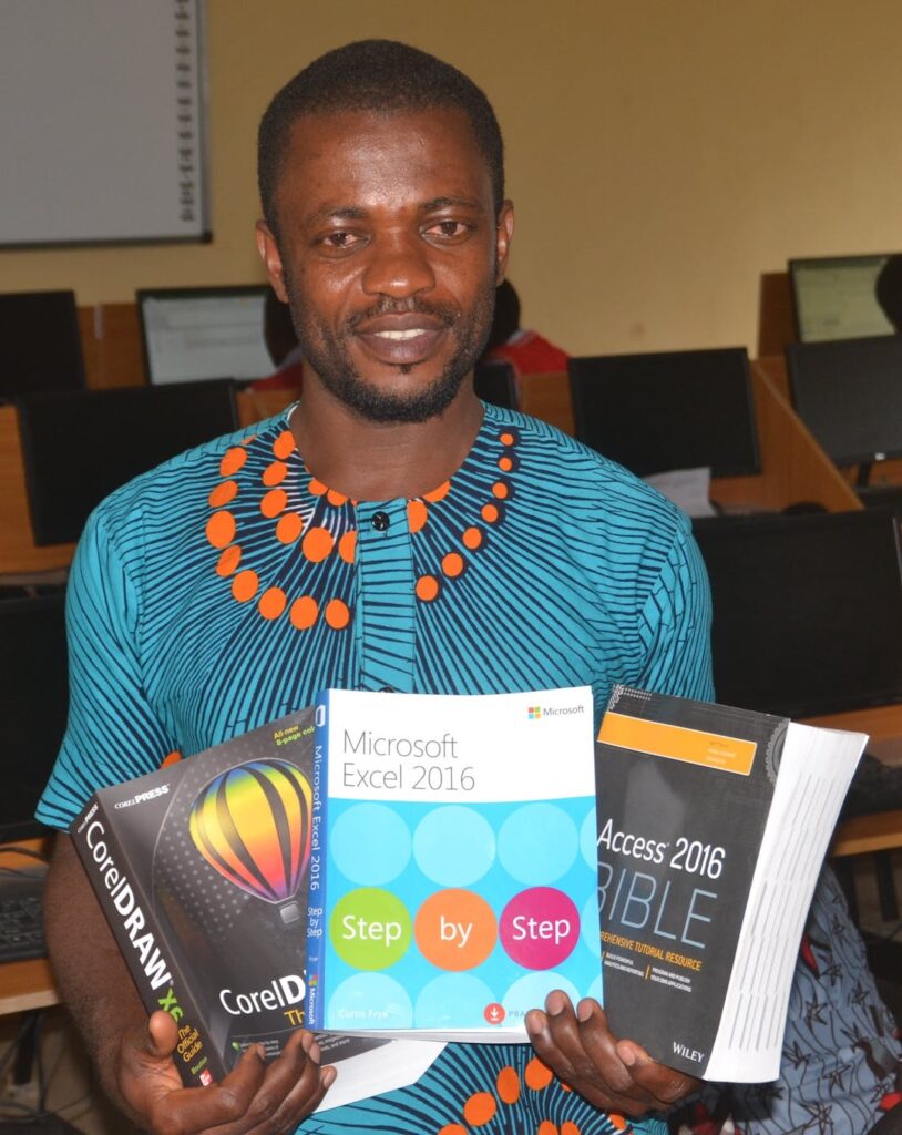 An image of a teacher holding newly donated books for the Empowering Young Minds initiative.