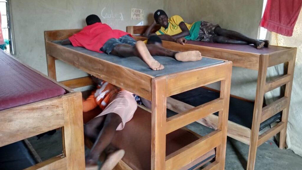 Children laying down on the newly supplied bed frames and mattresses at the Faith Needy Children's Home.
