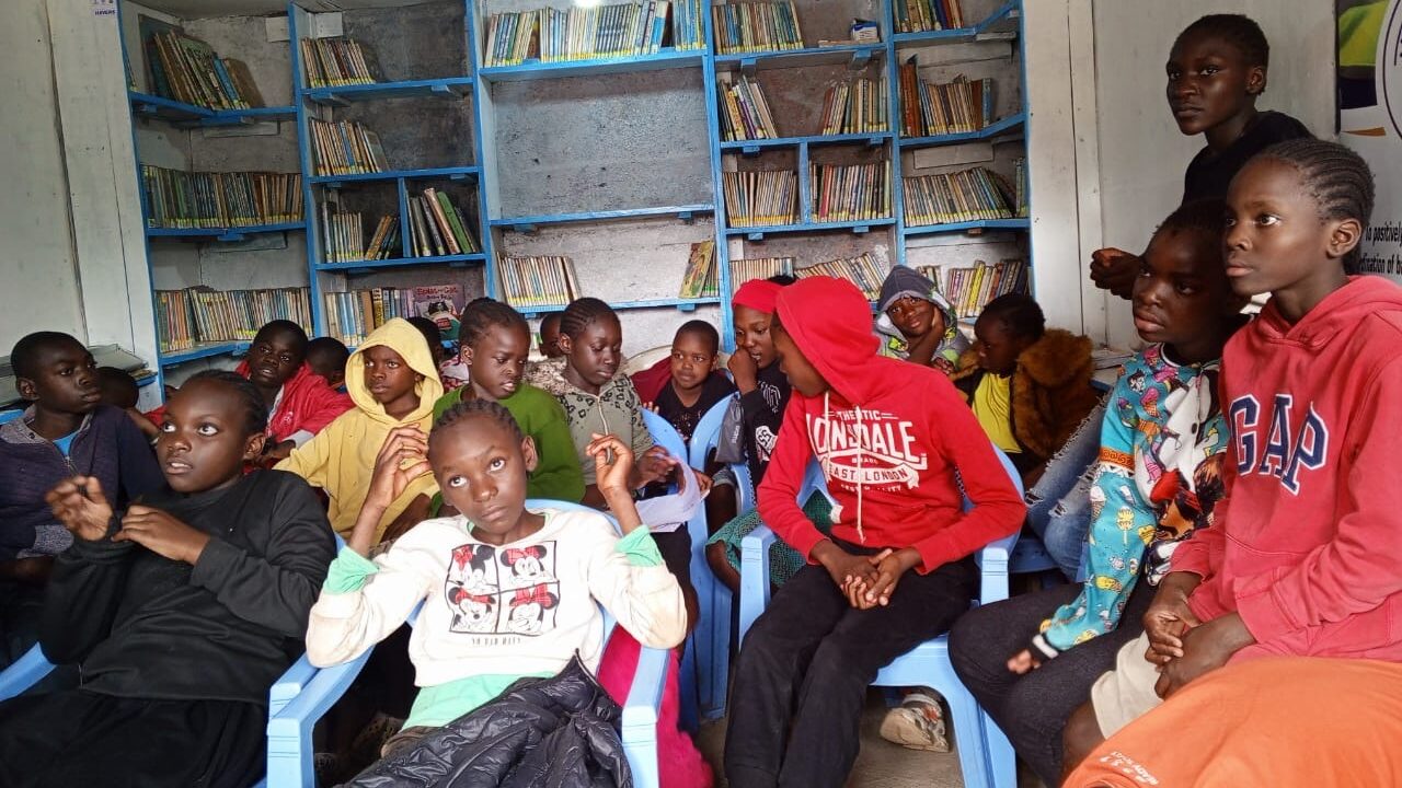 Image of children reading books in a traditional community library in sub-Saharan Africa. 