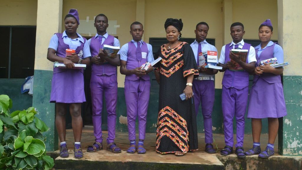 Students and Headmistress receiving the back to school supplies